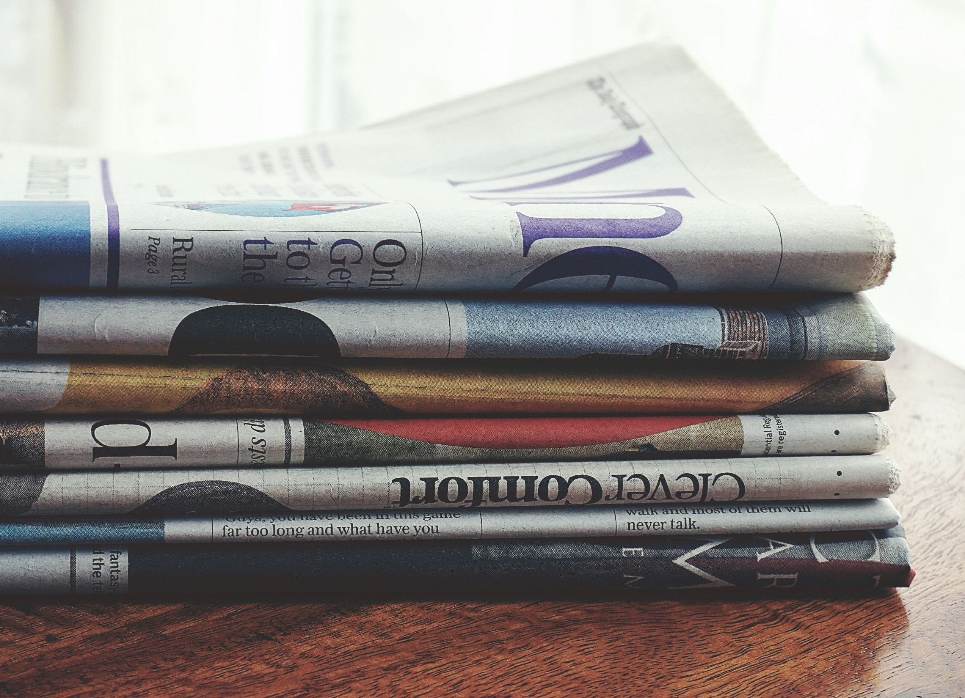 Pile de journaux posée sur une table en bois